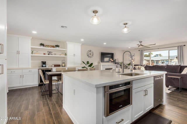 kitchen featuring dark wood-type flooring, wine cooler, sink, a kitchen island with sink, and white cabinets