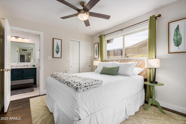 bedroom with connected bathroom, wood-type flooring, sink, ceiling fan, and a closet