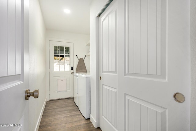 laundry room featuring washing machine and clothes dryer and dark hardwood / wood-style flooring