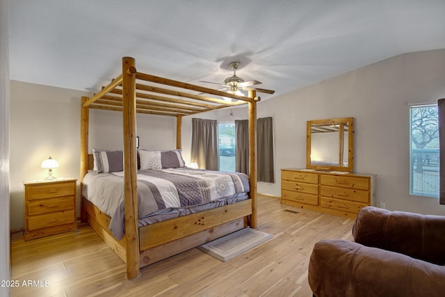 bedroom featuring a ceiling fan, lofted ceiling, multiple windows, and light wood finished floors