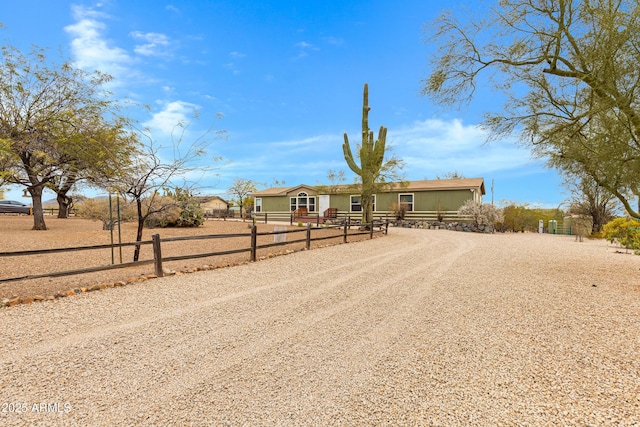 view of front of property featuring gravel driveway and fence