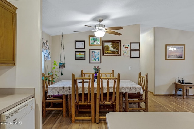 dining room featuring a ceiling fan, lofted ceiling, baseboards, and light wood finished floors