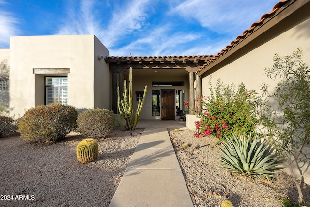 doorway to property with stucco siding and a tile roof