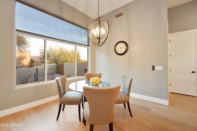 dining room with light wood-type flooring and a chandelier