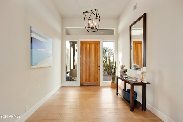 foyer with light hardwood / wood-style floors and a chandelier