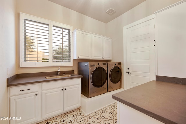 laundry room with independent washer and dryer, cabinets, sink, and light tile patterned flooring