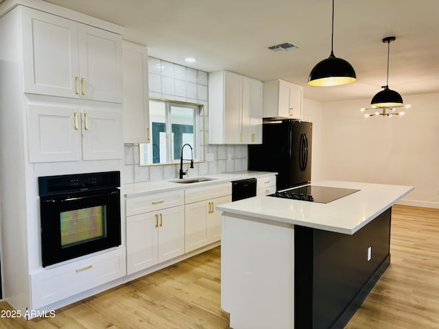 kitchen with black appliances, a sink, tasteful backsplash, white cabinetry, and recessed lighting