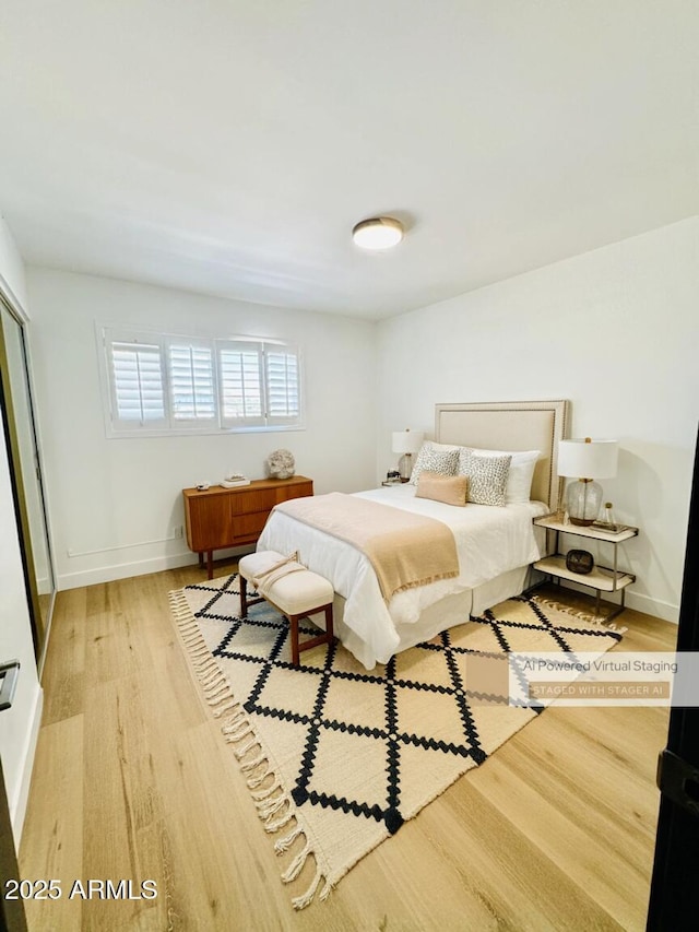 bedroom with light wood-type flooring and baseboards