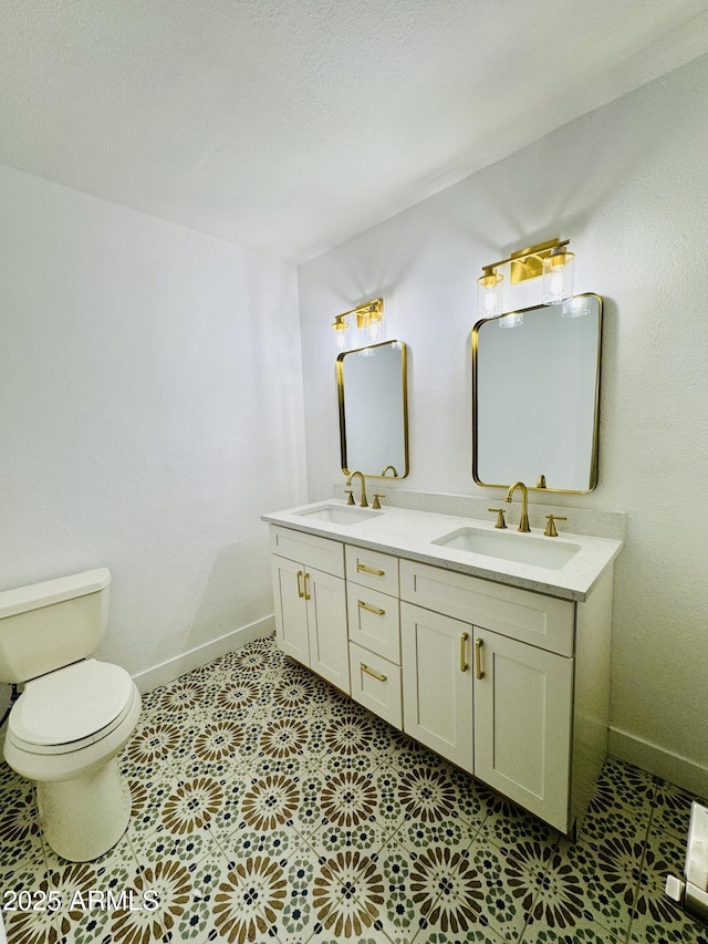 bathroom featuring double vanity, toilet, baseboards, and tile patterned flooring