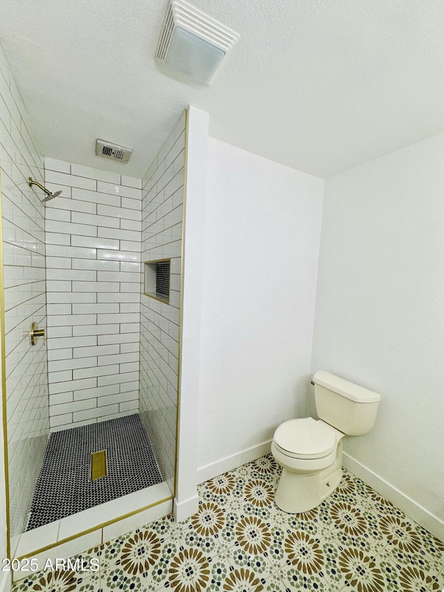 full bath with toilet, baseboards, a stall shower, tile patterned flooring, and a textured ceiling
