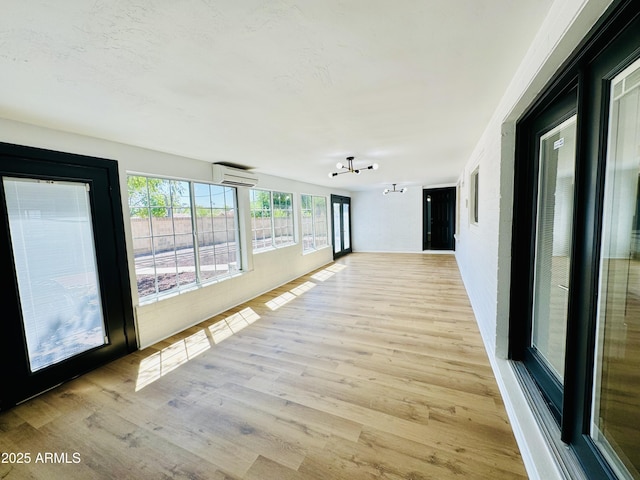 hall featuring light wood-style floors and a wall mounted air conditioner