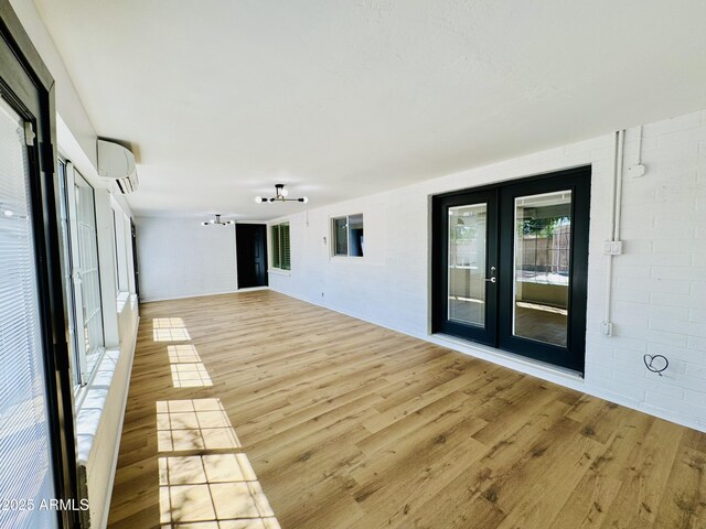 unfurnished sunroom featuring french doors and an AC wall unit