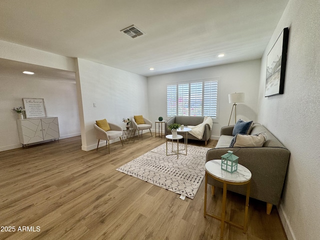 living area with wood finished floors, baseboards, and recessed lighting