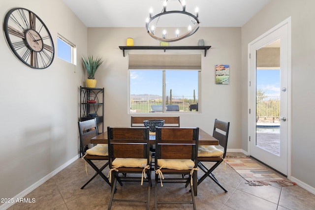 tiled dining room with an inviting chandelier and baseboards