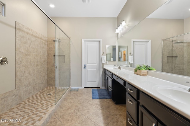 full bathroom featuring double vanity, a walk in shower, tile patterned floors, and a sink