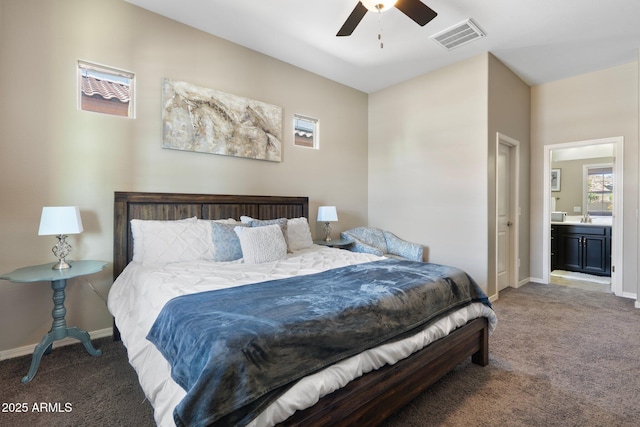 carpeted bedroom featuring baseboards, visible vents, ceiling fan, and ensuite bath