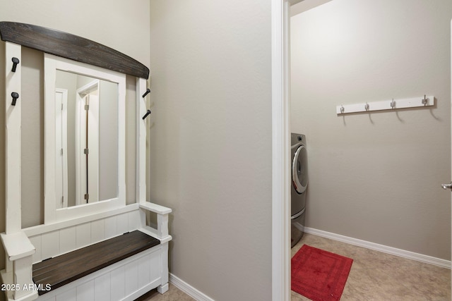 clothes washing area featuring baseboards, laundry area, and washer / clothes dryer
