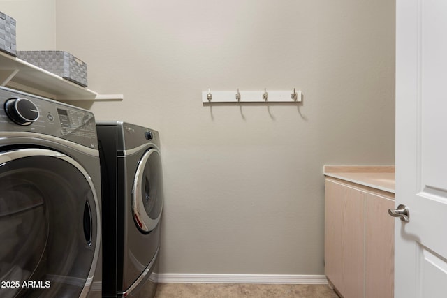 clothes washing area with baseboards, laundry area, and washing machine and clothes dryer