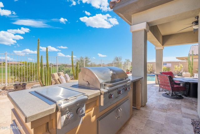 view of patio featuring an outdoor kitchen, ceiling fan, area for grilling, a fenced backyard, and a swimming pool