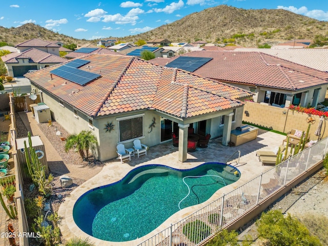 outdoor pool featuring a residential view, a mountain view, a fenced backyard, and a patio area