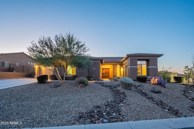 view of front of home featuring a garage, concrete driveway, and stucco siding