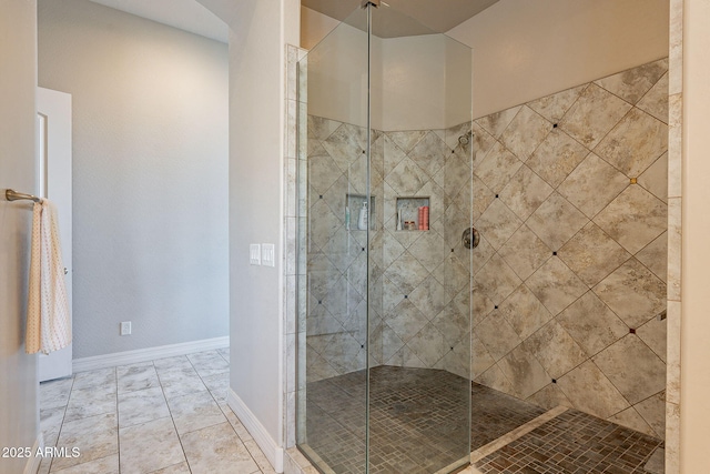 bathroom with a stall shower and baseboards