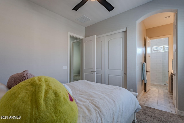 bedroom featuring light tile patterned floors, visible vents, a closet, and ceiling fan