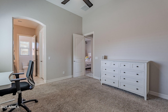 office area featuring light colored carpet, visible vents, arched walkways, and baseboards