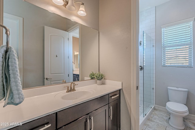 full bath with baseboards, toilet, a stall shower, and vanity