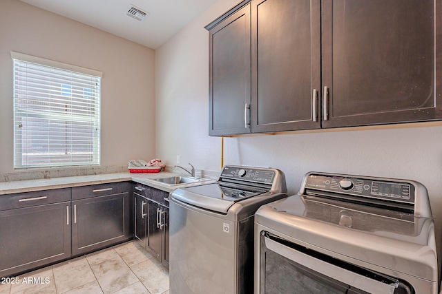 laundry area featuring light tile patterned floors, visible vents, cabinet space, a sink, and washer and dryer