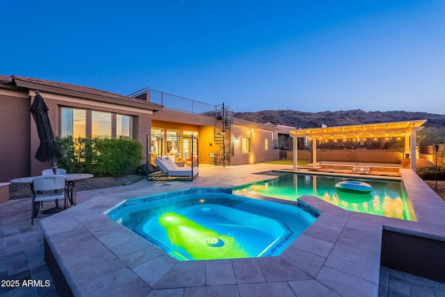 view of pool featuring a pool with connected hot tub, stairs, a mountain view, a pergola, and a patio