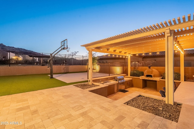 view of patio featuring area for grilling, a pergola, and fence