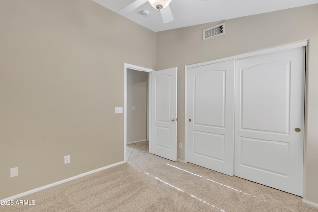 unfurnished bedroom with light carpet, a closet, and ceiling fan