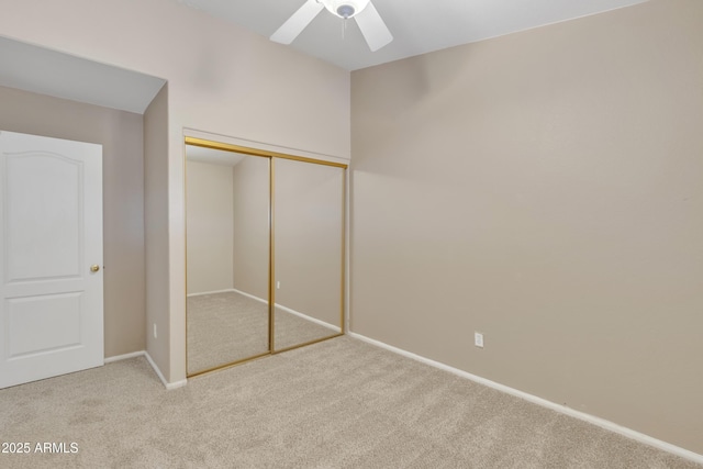 unfurnished bedroom featuring ceiling fan, a closet, and light carpet