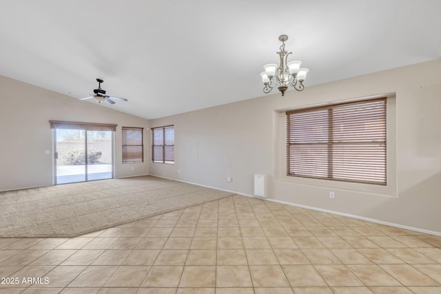 carpeted spare room with vaulted ceiling and ceiling fan with notable chandelier