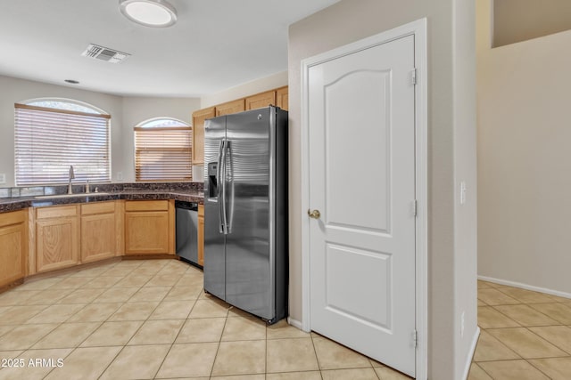 kitchen with stainless steel appliances, sink, and light tile patterned floors