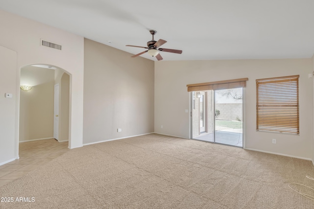 carpeted spare room featuring vaulted ceiling and ceiling fan