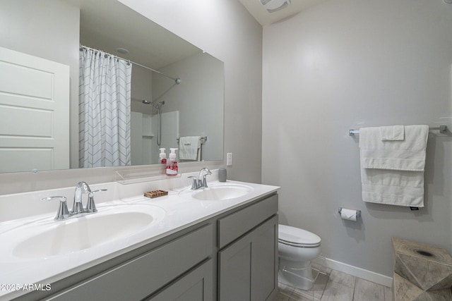 bathroom featuring vanity, toilet, and curtained shower