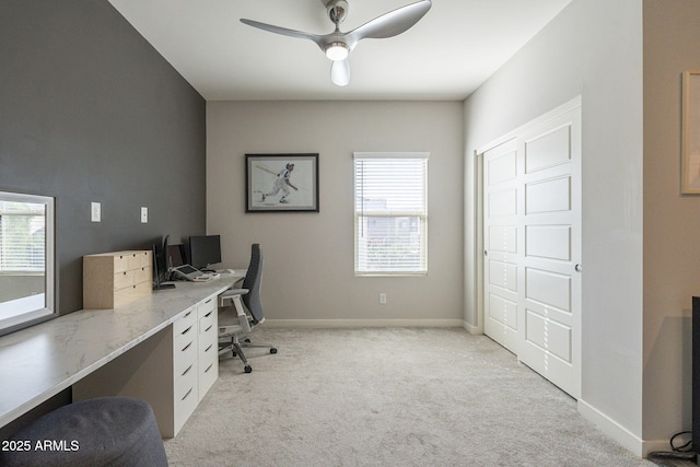 carpeted home office featuring ceiling fan