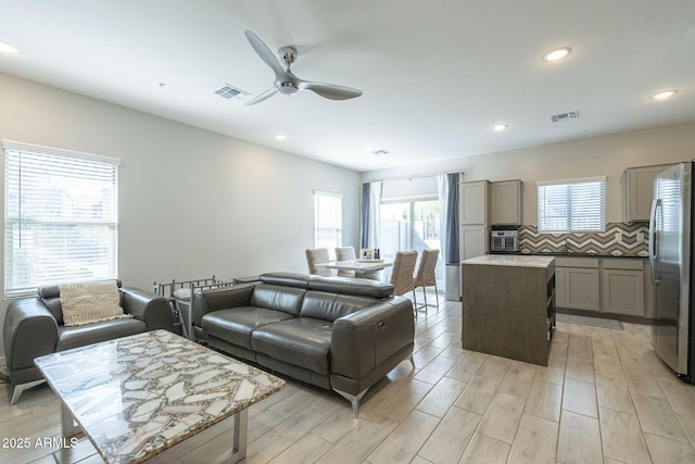 living room with ceiling fan and light hardwood / wood-style flooring