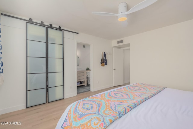 bedroom featuring ensuite bath, ceiling fan, and light hardwood / wood-style floors