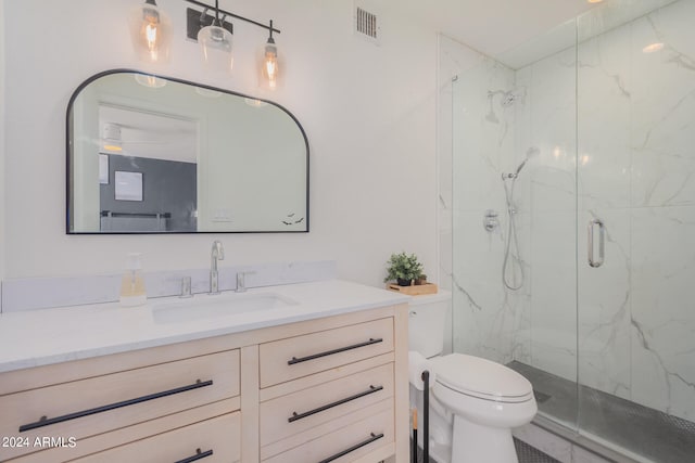 bathroom featuring toilet, a shower with door, and vanity