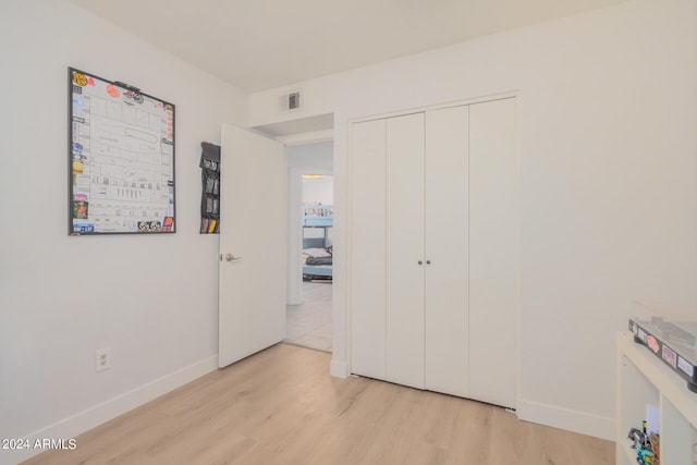 unfurnished bedroom featuring a closet and light hardwood / wood-style floors