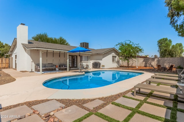 view of swimming pool featuring cooling unit and a patio area