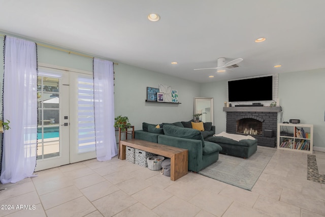 living room featuring french doors, a brick fireplace, light tile patterned floors, and ceiling fan