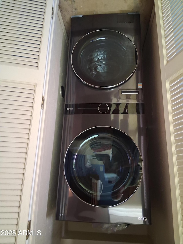 washroom with stacked washing maching and dryer and laundry area