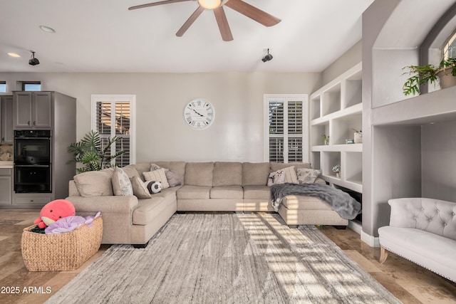 living room featuring built in shelves and a ceiling fan