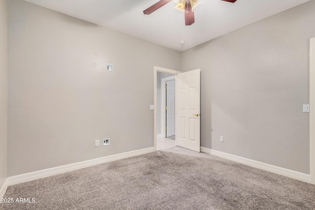 carpeted spare room featuring ceiling fan, visible vents, and baseboards