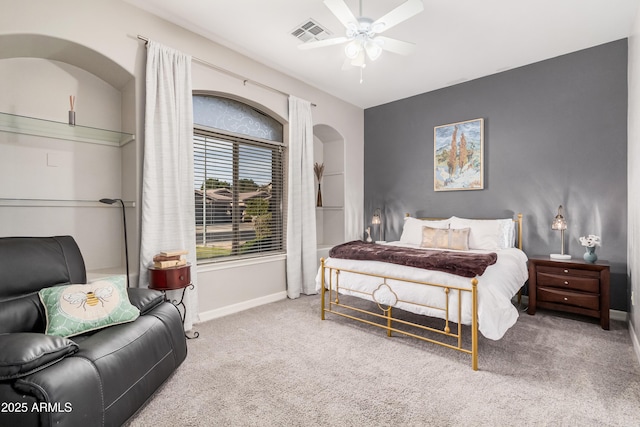 carpeted bedroom featuring arched walkways, a ceiling fan, visible vents, and baseboards