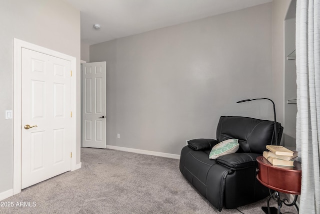 sitting room with baseboards and light colored carpet